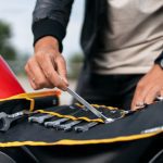 Motociklo oro filtro priežiūra ant darbo stalo su įrankiais